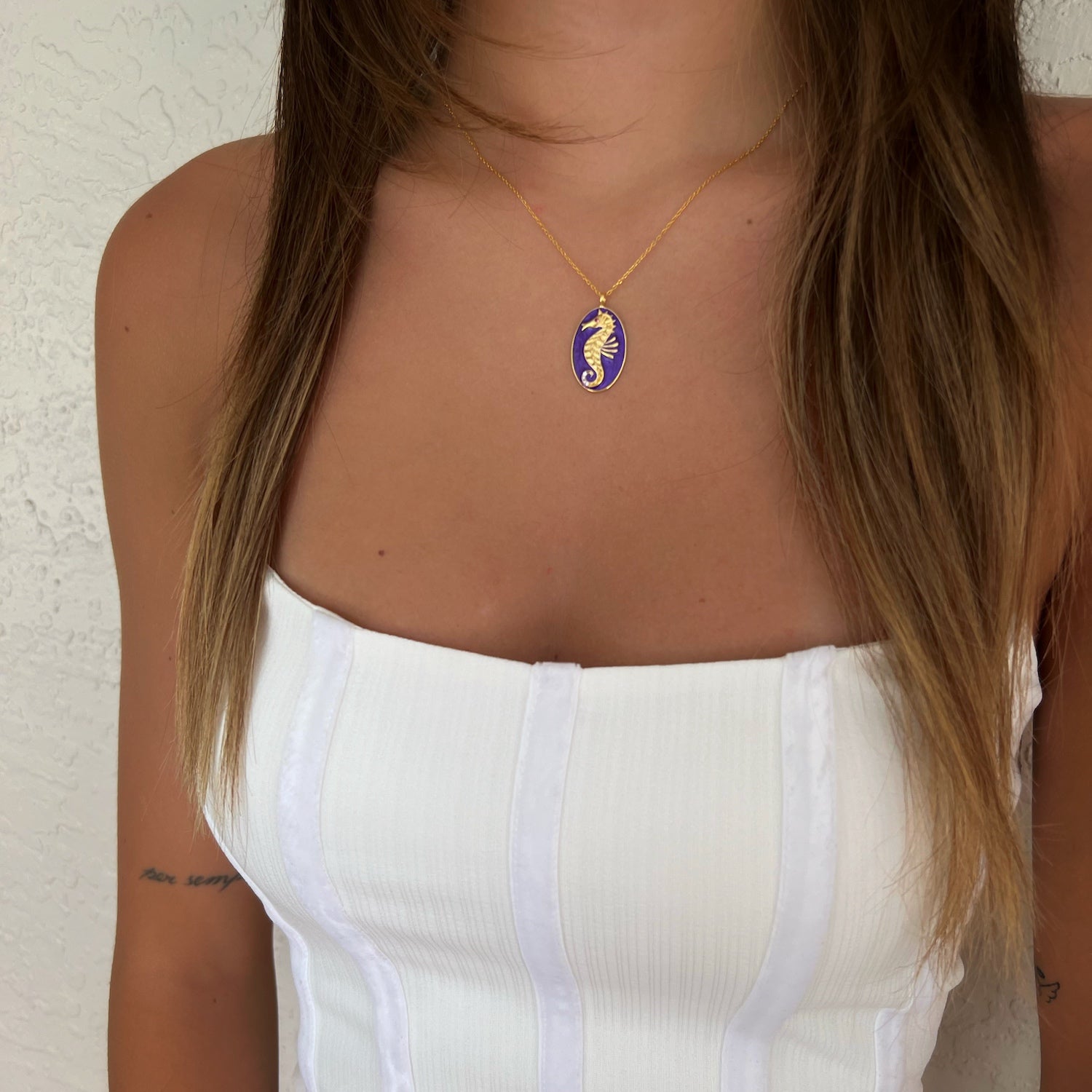 The Spirit Animal Blue Seahorse Necklace elegantly adorning the neck of a model, accentuating their grace and inner strength.