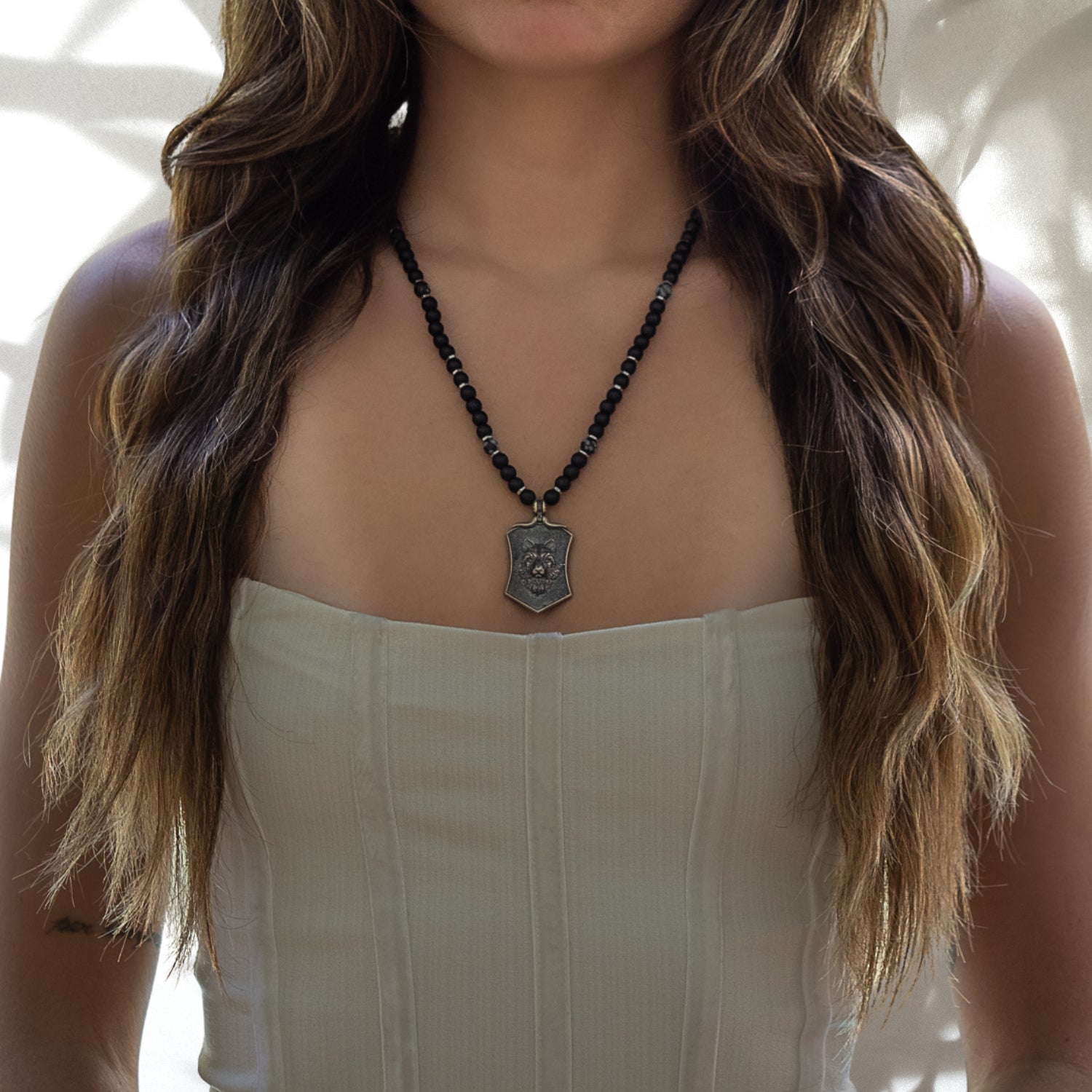 The model exudes confidence while wearing the Spirit Onyx Wolf Necklace, embodying the strength and spirit of the wolf.