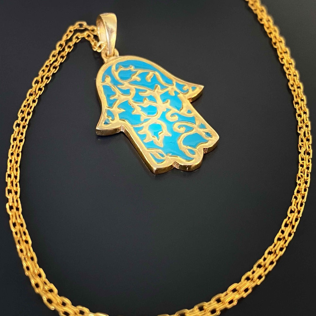 The Stay Positive Hamsa Necklace combines beauty and meaning, featuring a vibrant hamsa pendant made of sterling silver and 18K gold plating with colorful enamel accents, serving as a reminder to stay positive.
