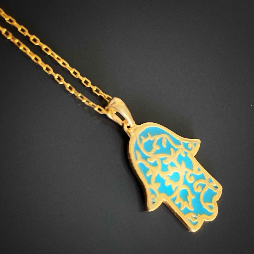  the Stay Positive Hamsa Necklace, accentuating the beauty of its hamsa pendant with enamel accents, serving as a stylish reminder to maintain a positive outlook.