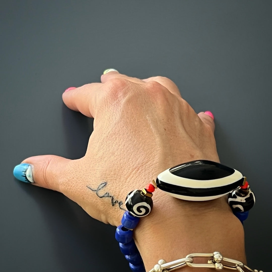 See the Third Eye Tibetan Bracelet on the hand model's wrist, adding a bold and stylish touch to her overall look.