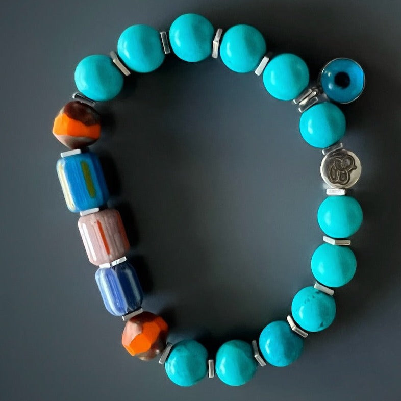 The Tropical Vibes Evil Eye Bracelet captures the essence of a tropical getaway with its turquoise stone beads, colorful African beads, and silver evil eye bead.