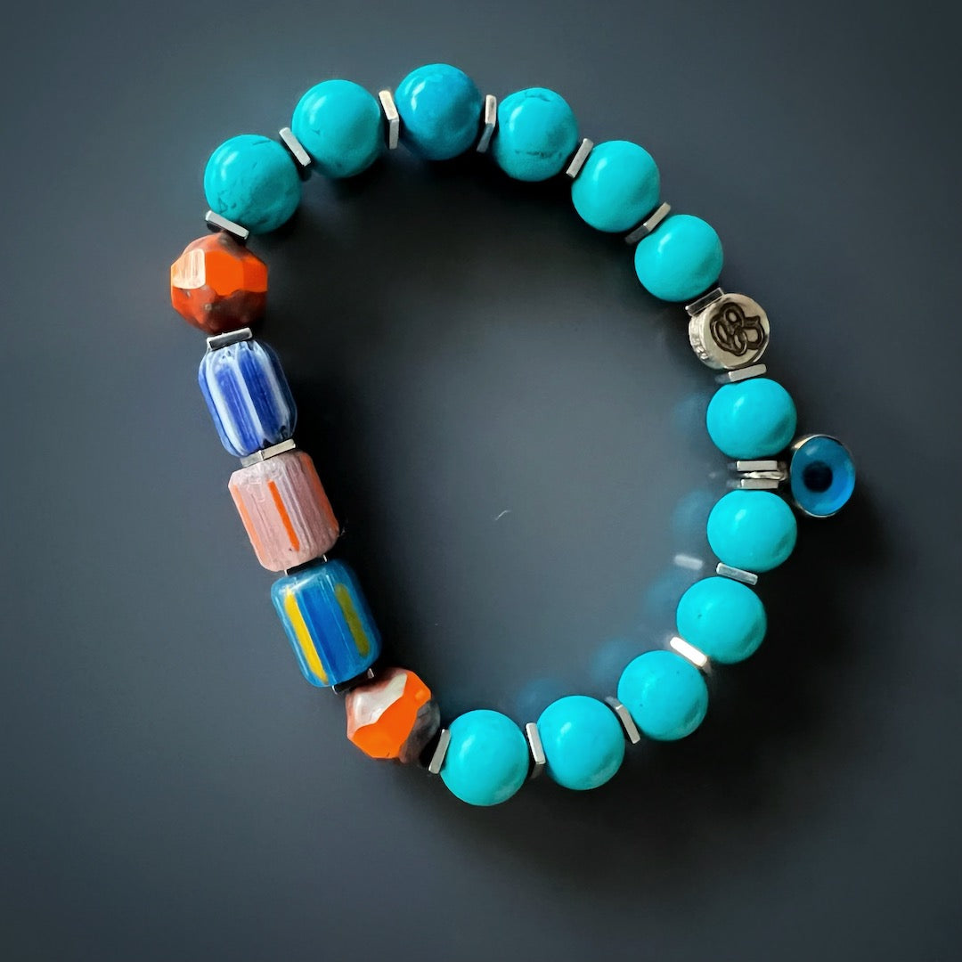 Embrace the vibrant energy of the Tropical Vibes Evil Eye Bracelet, featuring turquoise stone beads, African beads, and a glass evil eye bead.