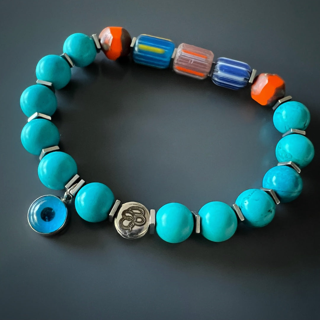 Discover the beauty of the Tropical Vibes Evil Eye Bracelet, adorned with turquoise stone beads, African beads, and a glass evil eye bead.
