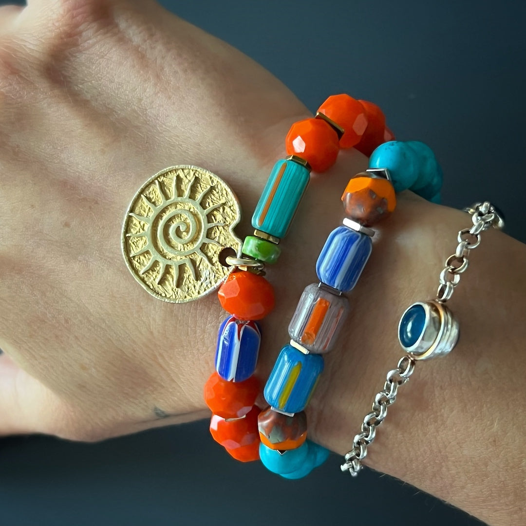 See how the Tropical Vibes Evil Eye Bracelet adds a touch of elegance and protection to the hand model&#39;s style with its turquoise stone beads, African beads, and glass evil eye bead.