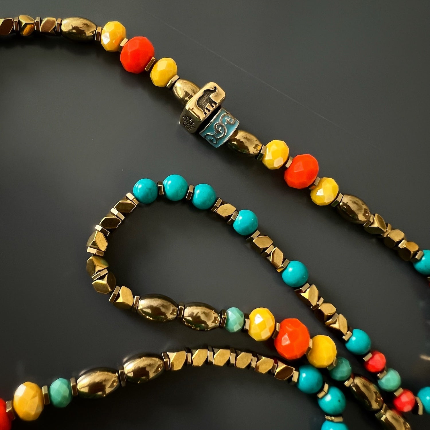 The vibrant yellow and orange crystal beads adding a playful touch to the Turquoise Blue Elephant Necklace