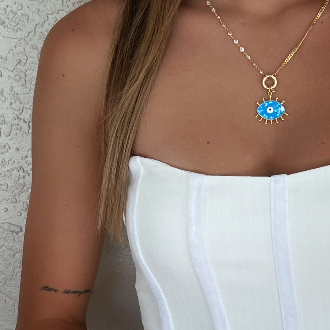 The Turquoise Evil Eye Chain Necklace elegantly adorning the neck of a model, adding a touch of charm to their overall look.