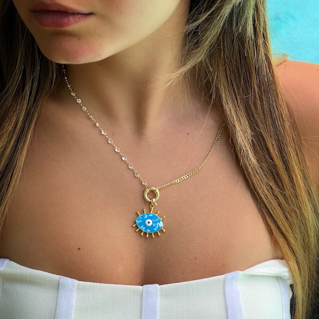 The Turquoise Evil Eye Chain Necklace accentuating the neckline of a model, creating a chic and captivating style statement.
