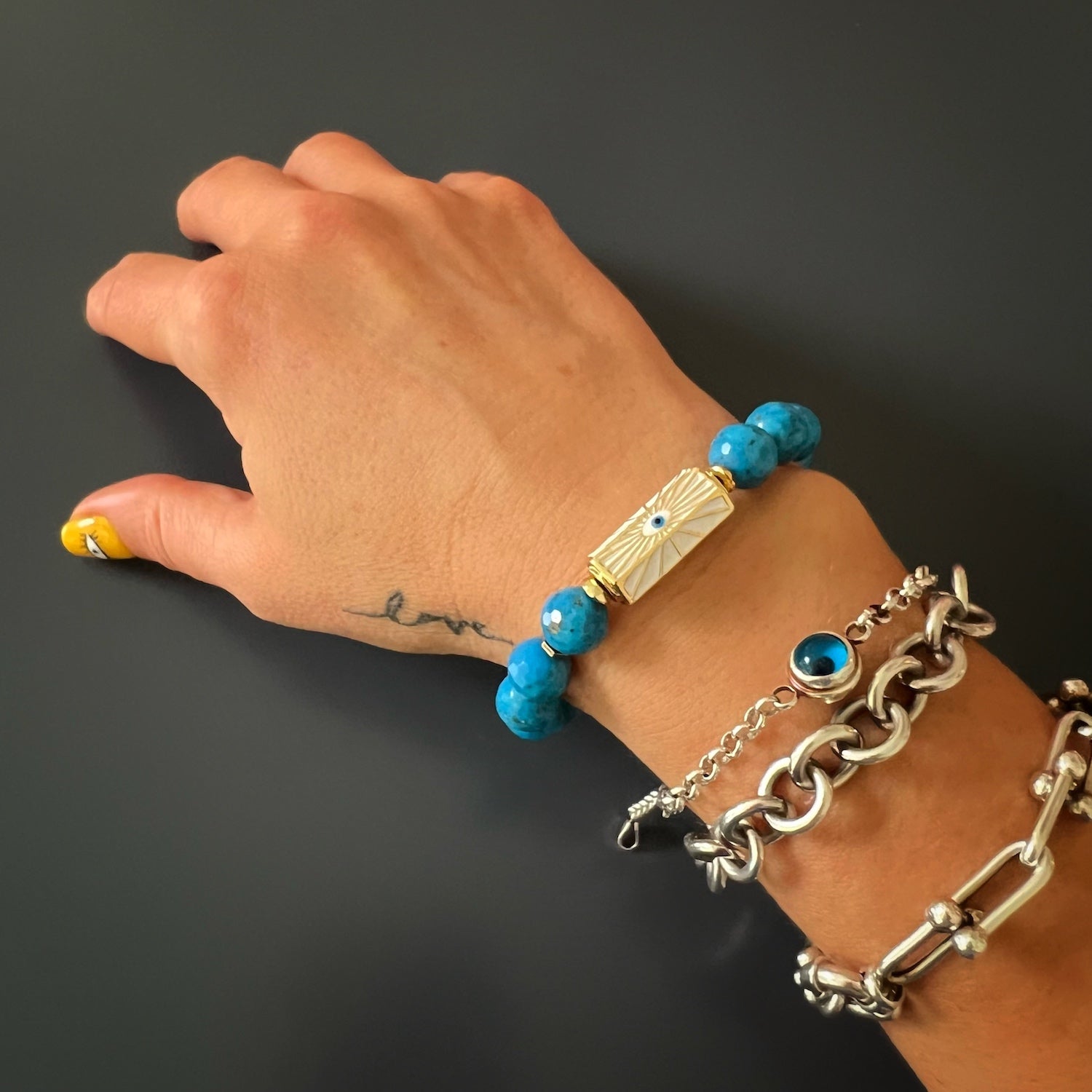 See how the Turquoise Luck and Protection Bracelet adorns the hand model&#39;s wrist, adding a touch of spirituality and enhancing her style.