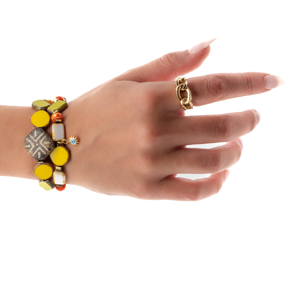 Hand model showcases the vibrancy of the Unique African Bracelet Set, highlighting its colorful beads and gold plated evil eye charm.