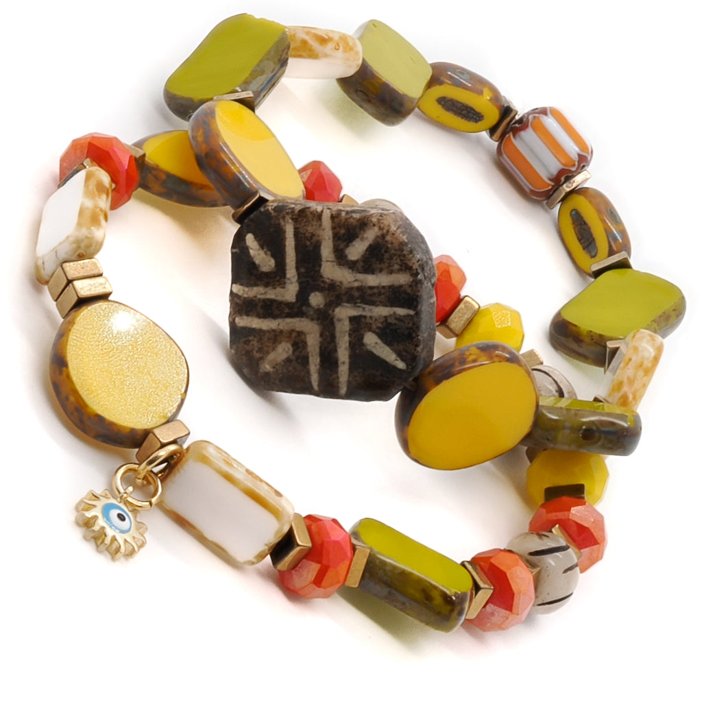 Discover the vibrant beauty of the Unique African Bracelet Set, featuring colorful African beads, Nepal beads, and a gold plated evil eye charm.