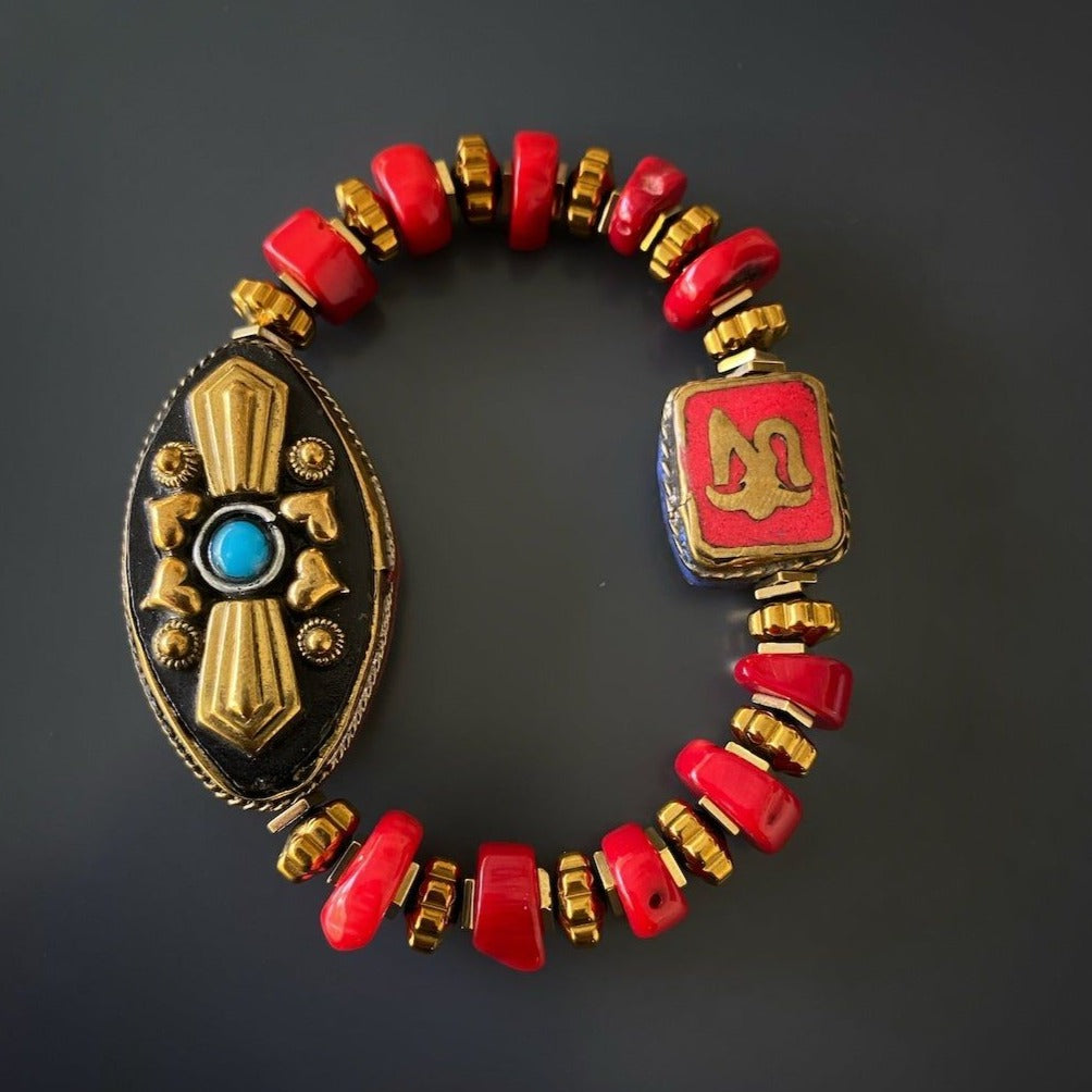 Adorn your wrist with the Vintage Style Ethnic Om Bracelet, showcasing a unique blend of ethnic elements and vibrant red coral beads.