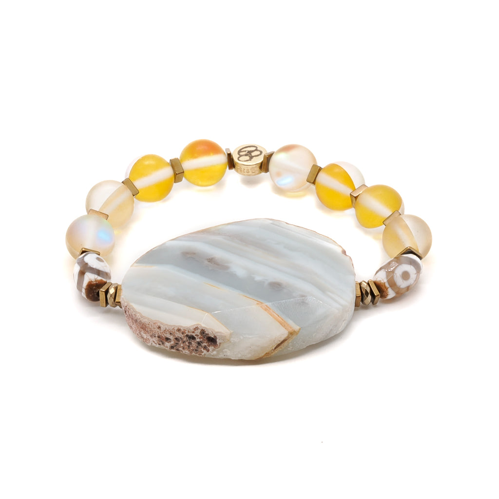 Admire the beauty of the Yellow Chunky Agate Bracelet, featuring a large natural row Agate stone surrounded by cat eye and Nepal eye beads.