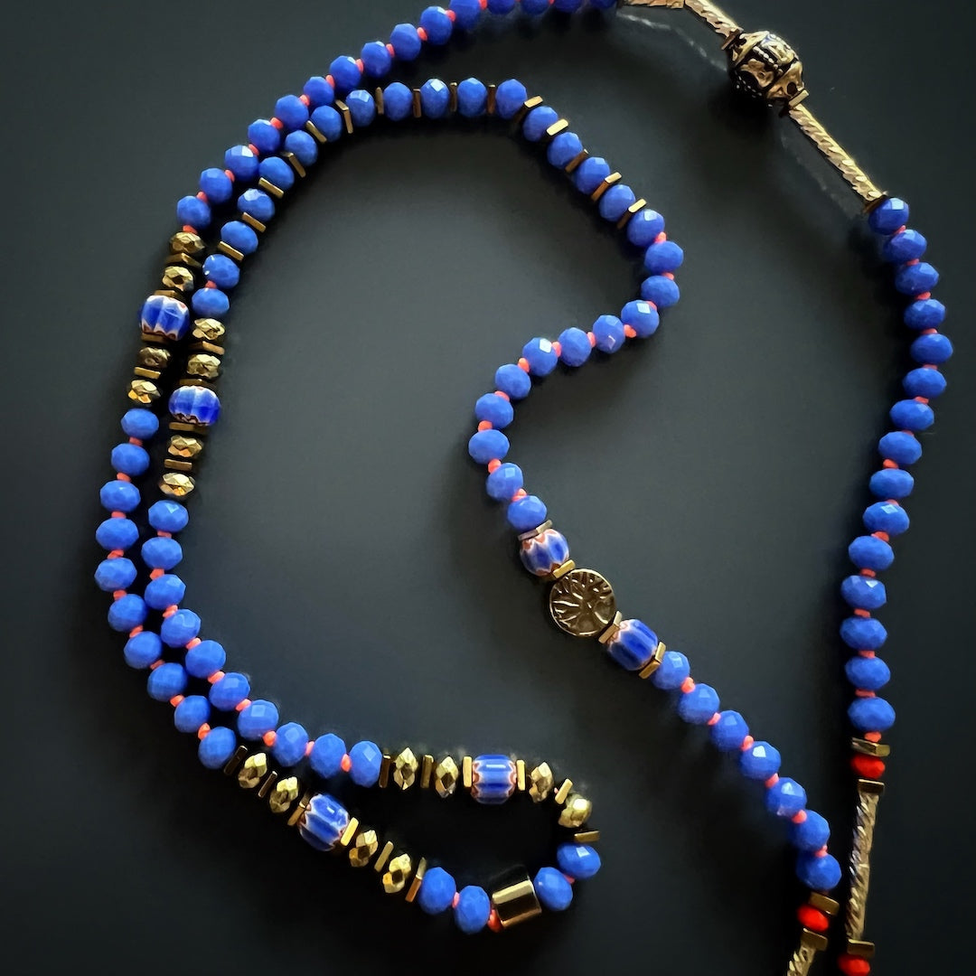 Yoga Meditation Necklace with a unique combination of blue and red Nepal beads, gold-plated tube beads, and a sterling silver meditation pendant.