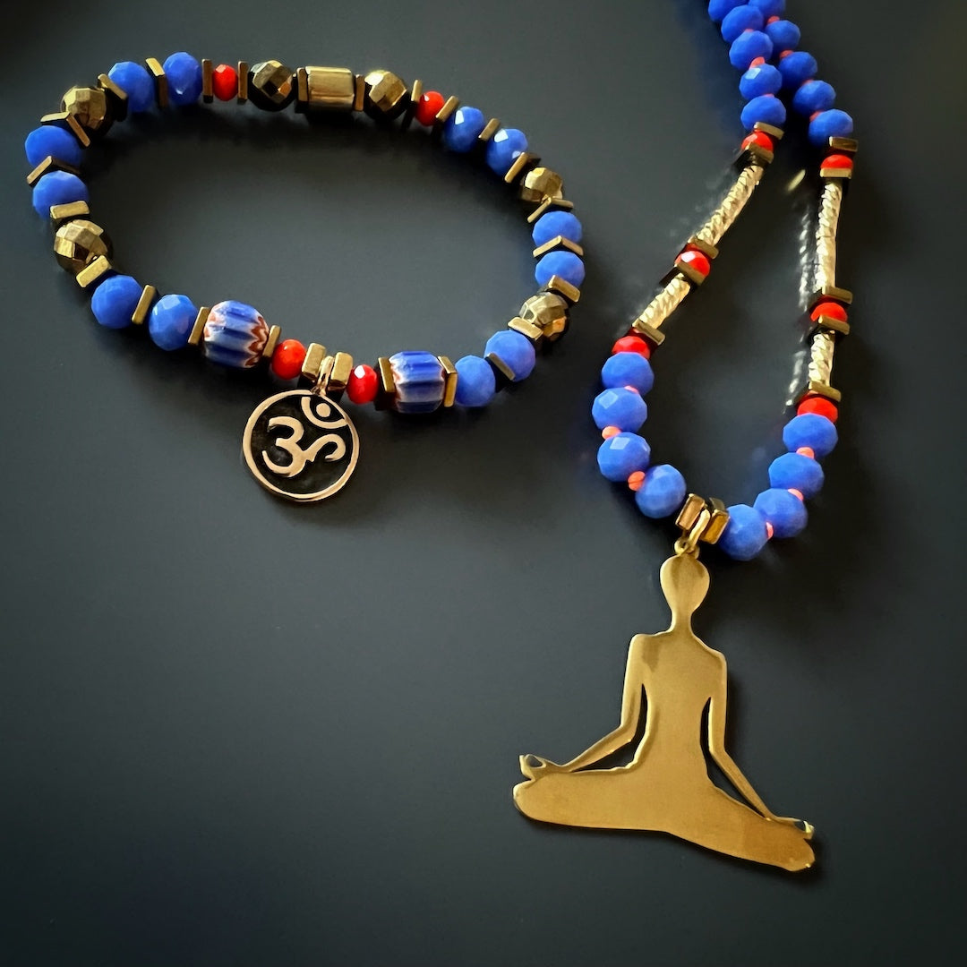 Handmade necklace with a harmonious blend of blue and red Nepal beads, gold-plated tube beads, and an intricate Om Mani Padme Hum mantra bead.