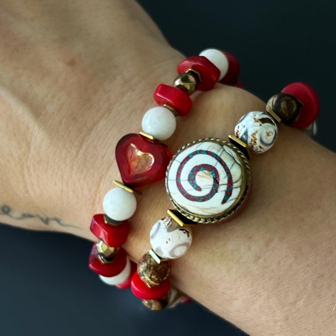 Experience the peaceful energy as the hand model wears the Yoga Spirit Mystic Bracelet, adorned with coral stone beads, Nepal meditation beads, and gold color hematite spacers.