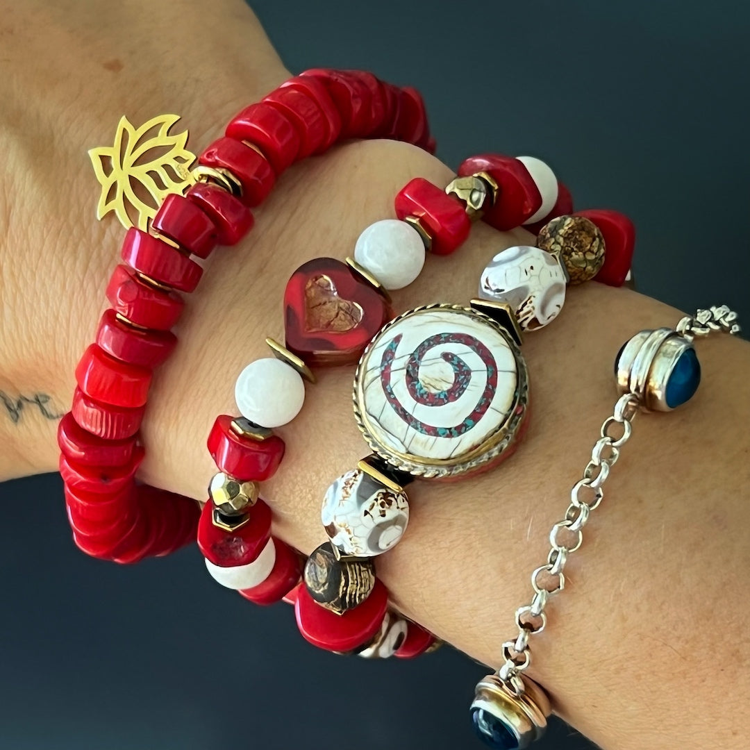 The Yoga Spirit Mystic Bracelet beautifully complements the hand model&#39;s style, showcasing the coral stone beads, Nepal meditation beads, and the spiritual essence of the spiral charm.