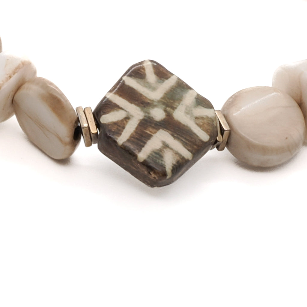 Lovingly handcrafted African Bone Beads bracelet with cream-colored African seed beads and a beautiful Nepal bead, perfect for meditation and yoga