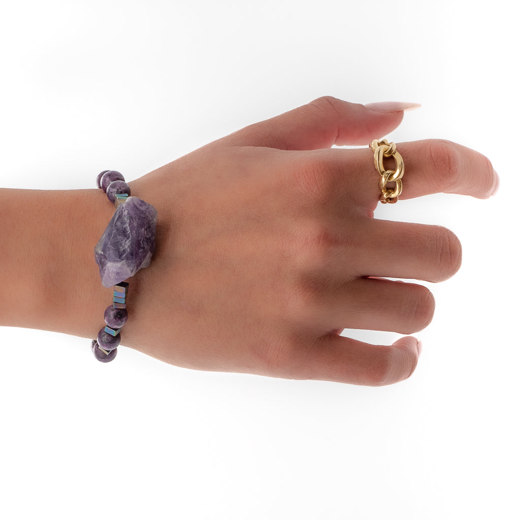 A hand model wearing purple jasper and raw amethyst to create a powerful combination 