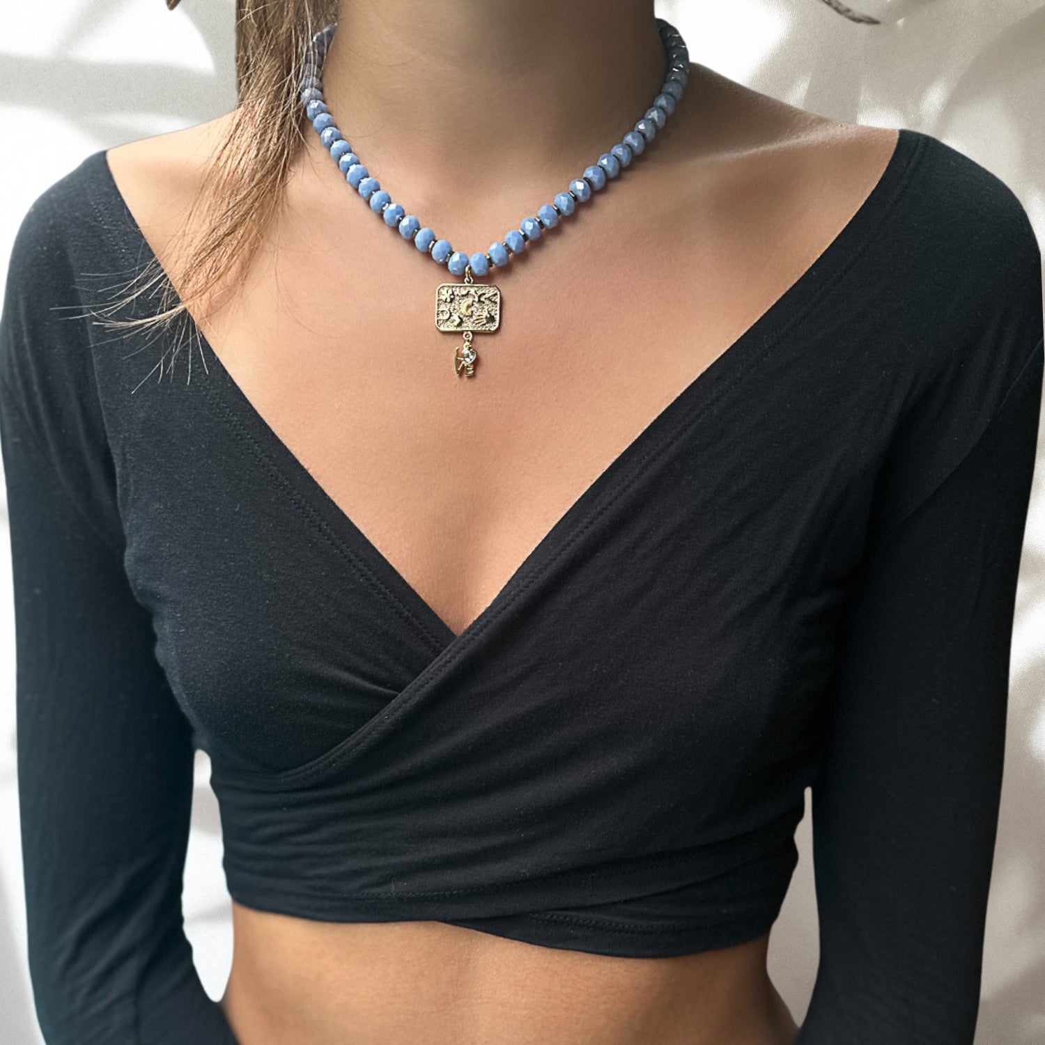 The model wearing the Best Wishes Magical Talisman Necklace with a stunning blue outfit.