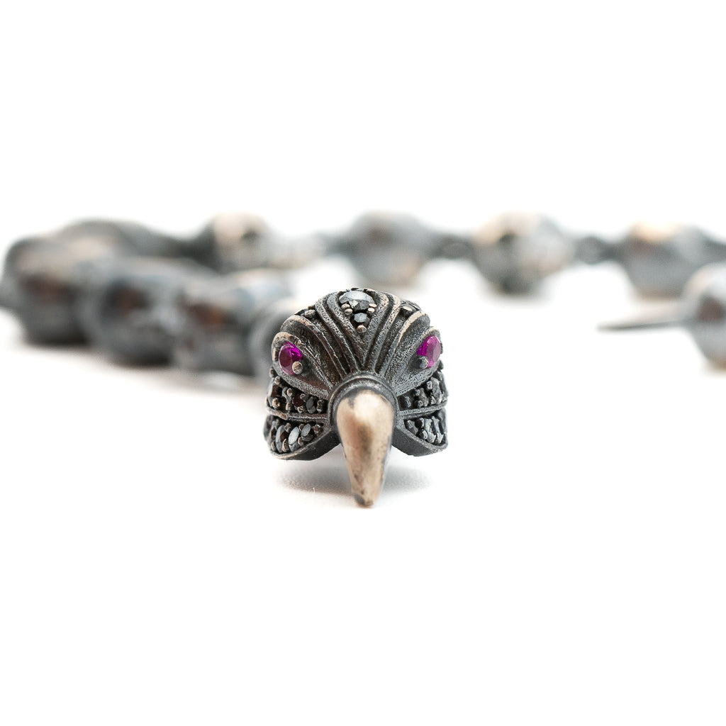 An image showcasing the intricate craftsmanship of the bracelet, highlighting the hand-carved skulls and the detailed eagle and tulip clasp. The sterling silver material shines elegantly.