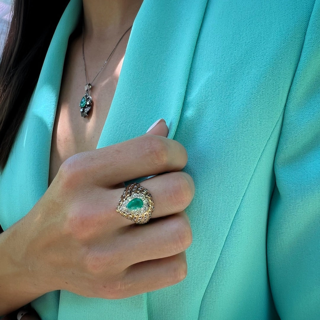 Hand model showcasing the Emerald &amp; Diamond Eye Ring, symbolizing fidelity and love with its striking emerald centerpiece and sparkling diamonds.