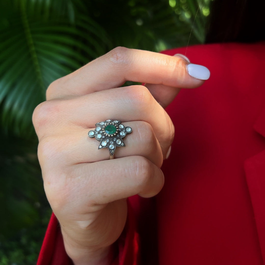 Hand model wearing the elegant Emerald Star Ring, showcasing the beautiful 0.53ct emerald at the center, surrounded by dazzling diamonds, representing fidelity and true love with its captivating design.