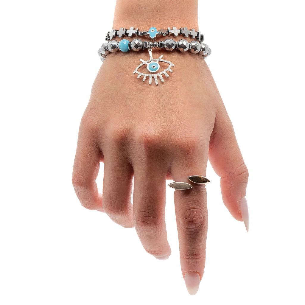 Stylish hand model showcasing the handmade bracelet set with silver hematite beads, evil eye charm, and Hamsa charm