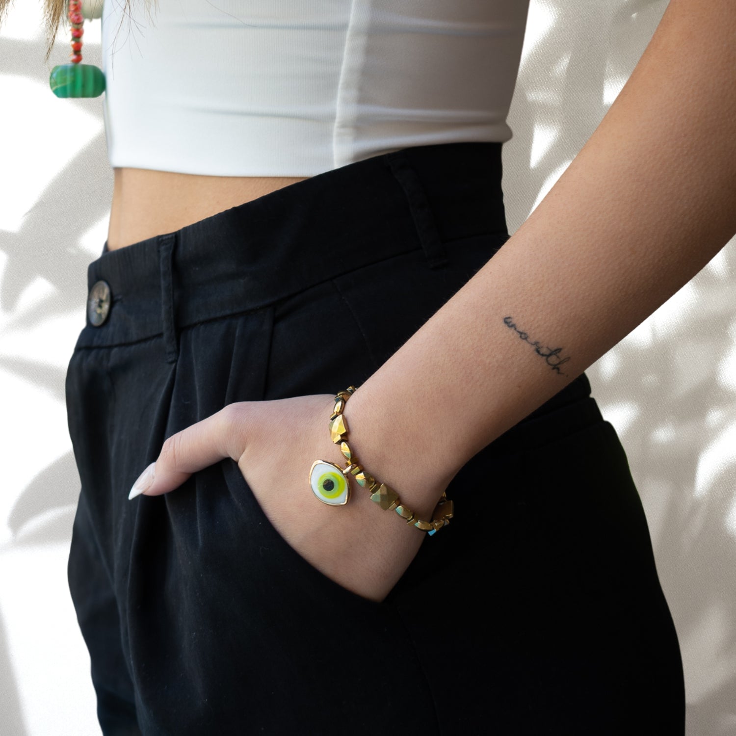 A hand model wearing the Green Eye Vitality Bracelet, showcasing its stunning design and vibrant green Evil eye charm. The bracelet adds a stylish touch to the model&#39;s wrist, exuding elegance and positive energy.