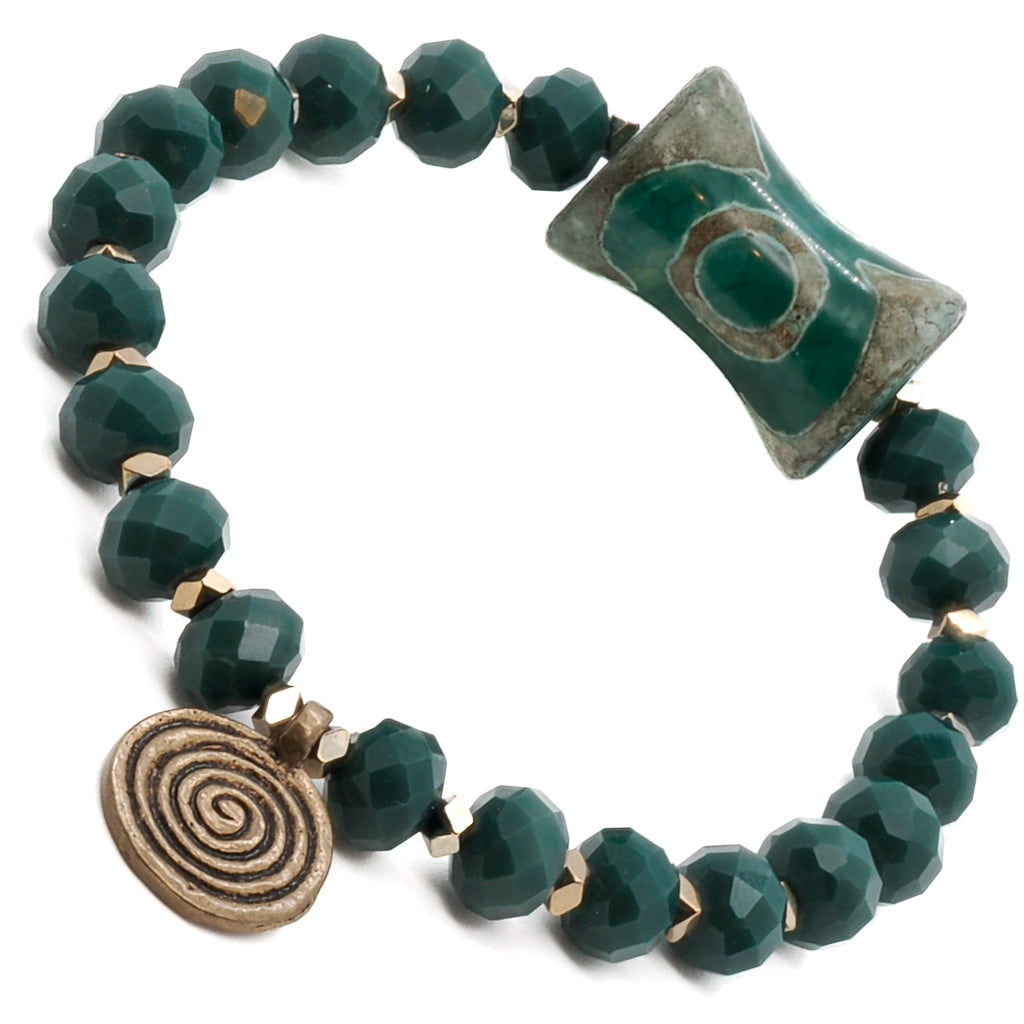 The big green eye Nepal bead stands out as a captivating centerpiece, exuding a sense of protection and intuition. The brass spiral charm adds a whimsical touch to the overall design, symbolizing growth and transformation.