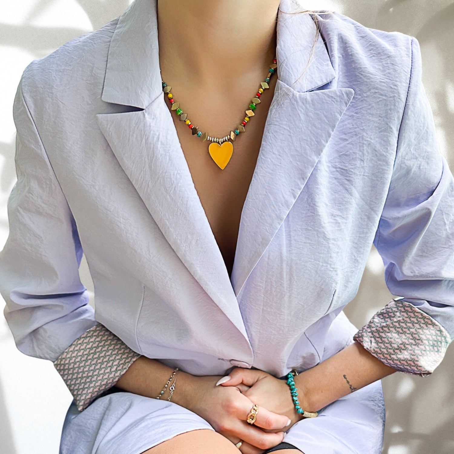 A model joyfully wearing the vibrant Joyful Heartbeat Necklace, adding a playful touch to her ensemble.