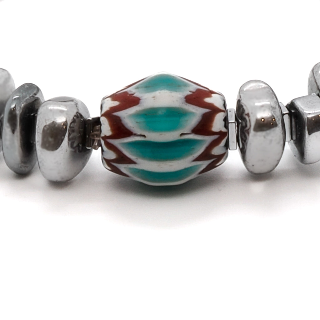 The Juno Bracelet, a symbol of protection and positive energy, adorned with silver color nugget hematite stone beads and a beautiful handmade Turquoise and Red Nepal bead.