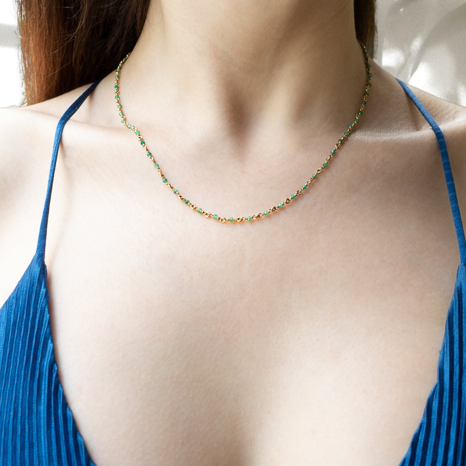 Another image of a model wearing the Karya Jade Gold Necklace, highlighting its eye-catching design and the beauty of the natural stones.