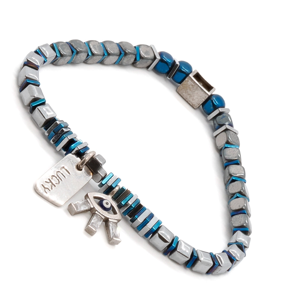 Experience the allure and protection of the Lucy Evil Eye Bracelet, designed with blue and silver hematite beads and a mesmerizing 925 sterling silver evil eye charm embellished with Swarovski crystals.