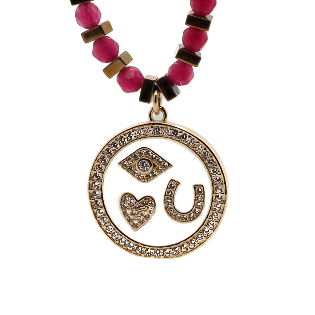 Carry the power of luck and protection with the Magic Blessings Pink Necklace, featuring an evil eye, horseshoe, heart pendant, and lucky flowers, a meaningful accessory handcrafted with hot pink faceted jade stone beads and gold-colored hematite spacers.