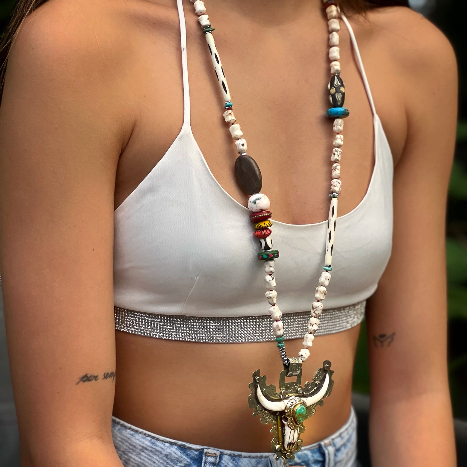 The model wears the Mystic Longhorn Unique Necklace, showcasing its striking design and the powerful symbolism of the longhorn pendant, making a bold statement and capturing attention.