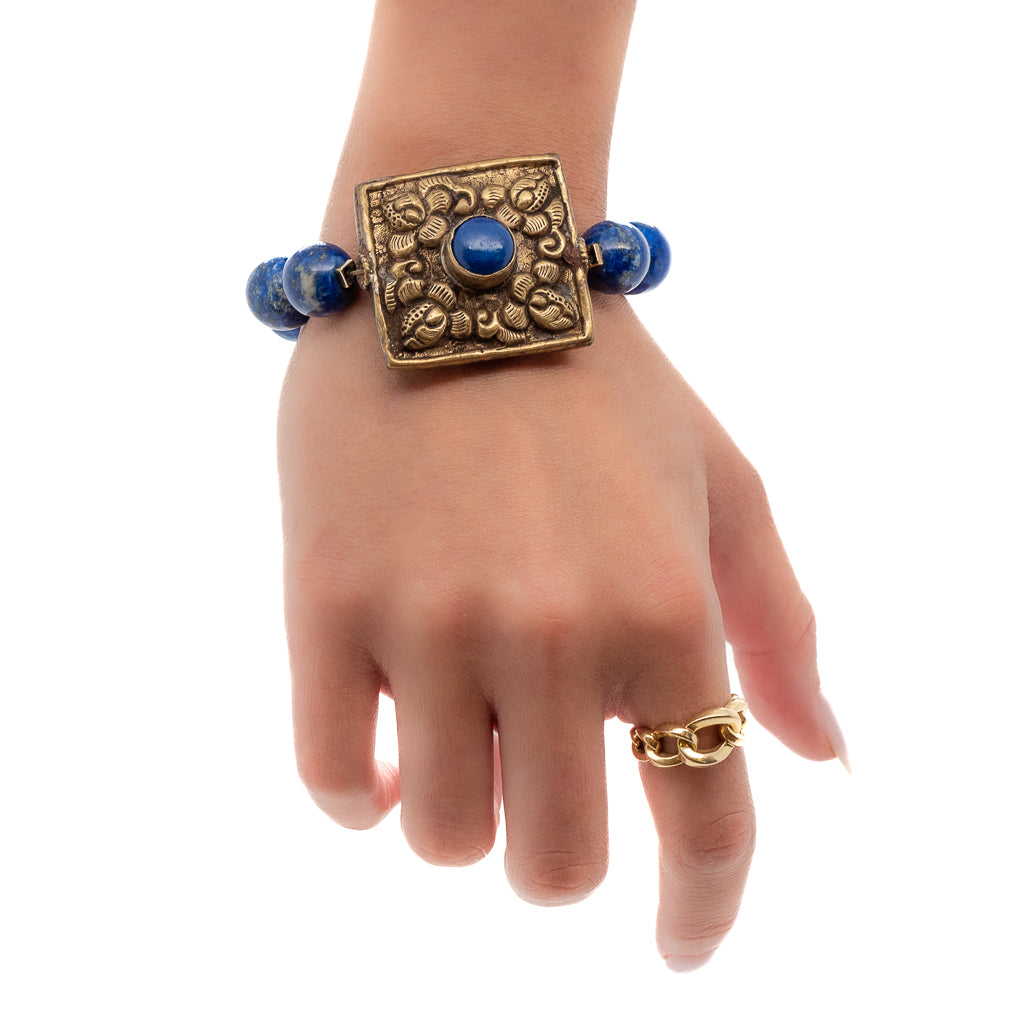 The hand model wears the Nepal Energy Bracelet, showcasing the beauty of the lapis lazuli beads and Nepalese brass piece.