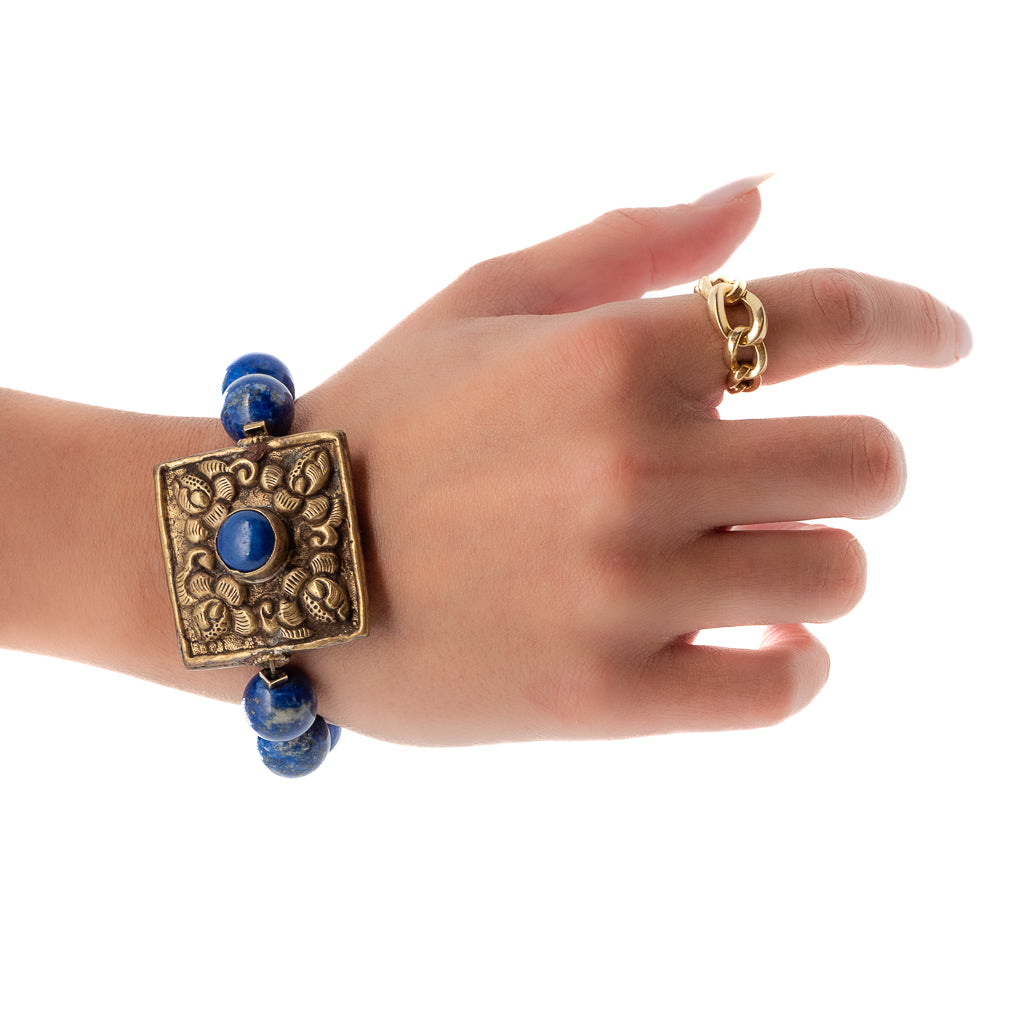 See the Nepal Energy Bracelet adorning the hand model&#39;s wrist, radiating elegance and the intricate craftsmanship of Nepal.