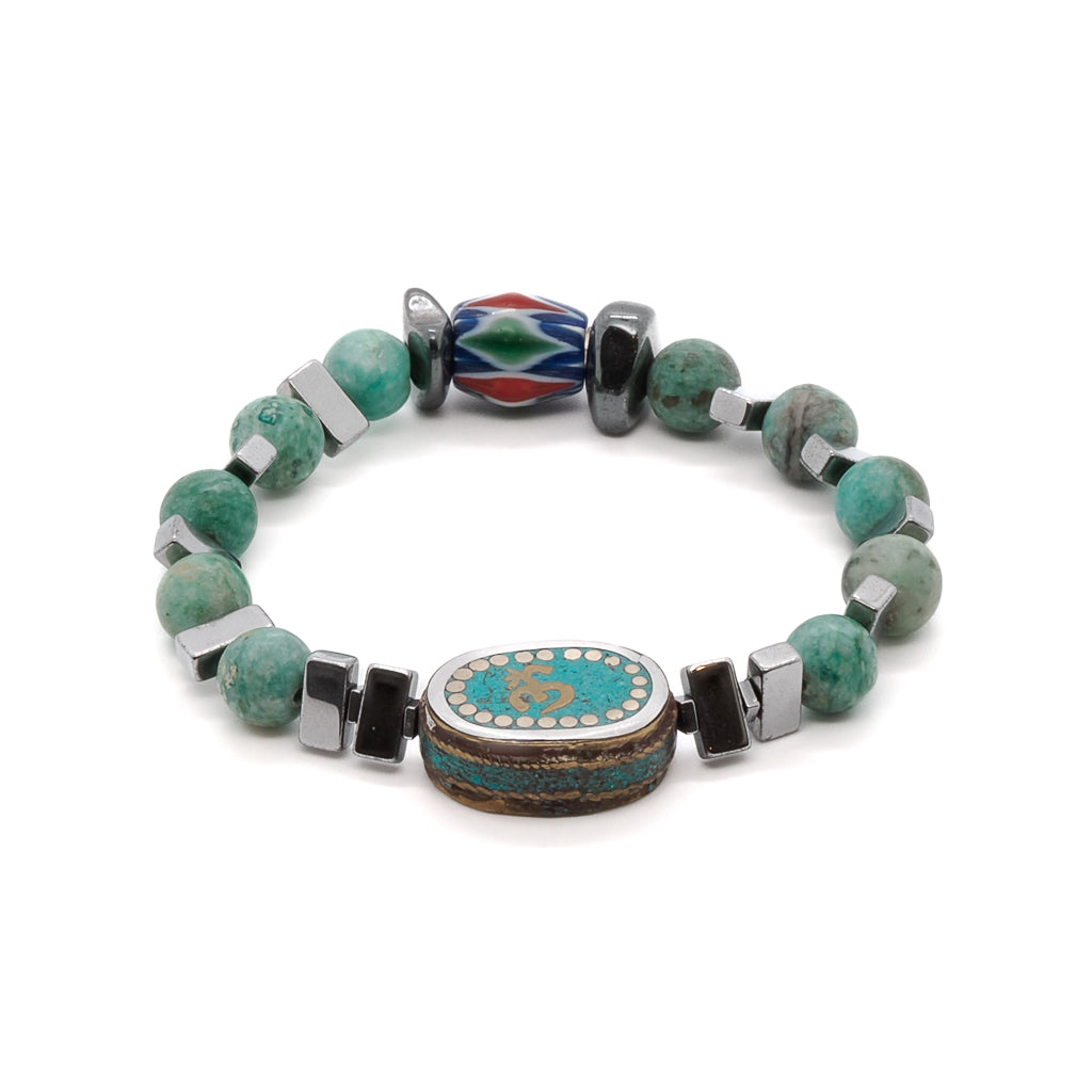 Discover the beauty of the Om Mystic Bracelet, featuring a handmade Ethnic Om Mantra charm bead with turquoise inlay.