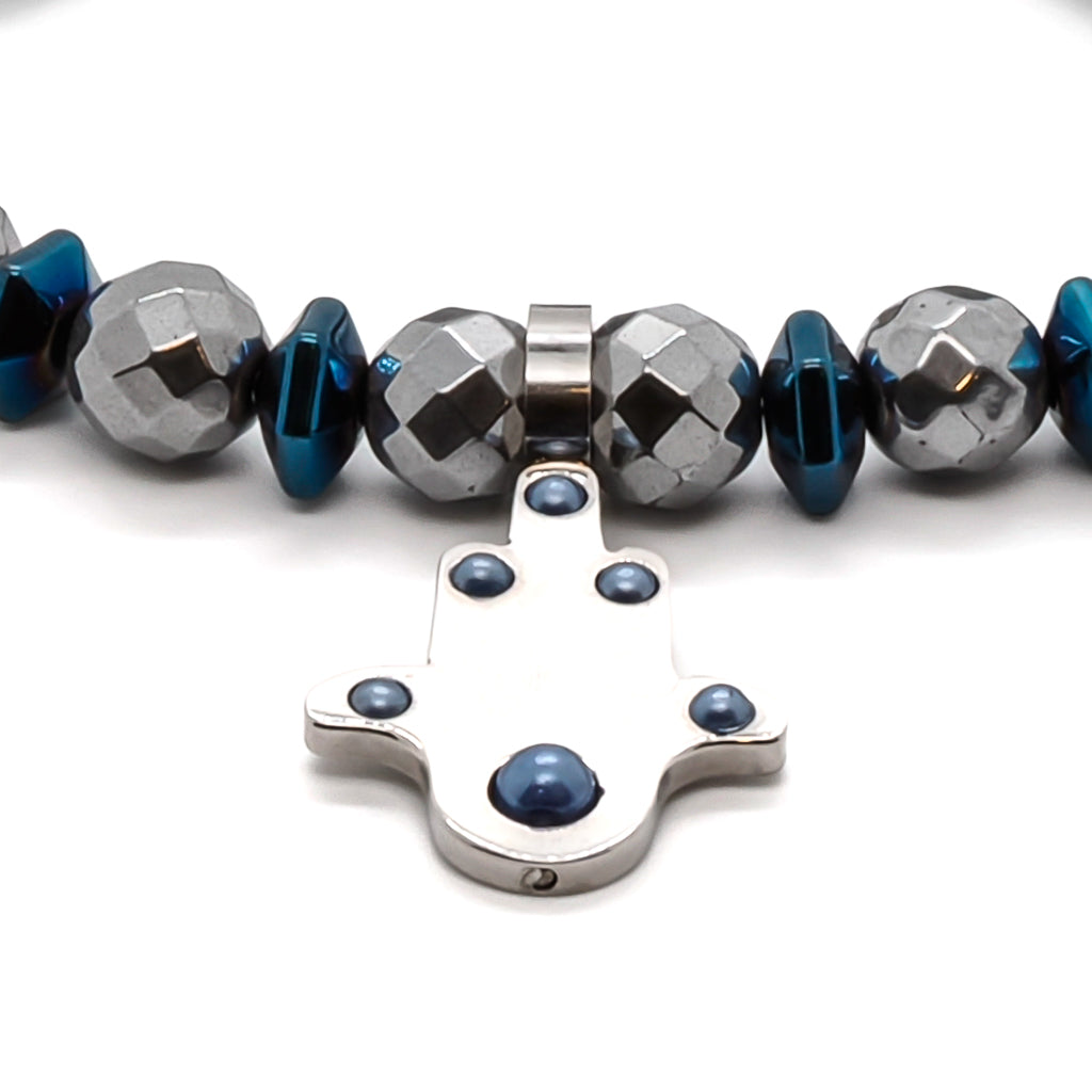 Discover the positive vibrations of the Positive Hamsa Bracelet, featuring silver hematite beads, blue hematite pyramid beads, and a stainless steel Hamsa charm.