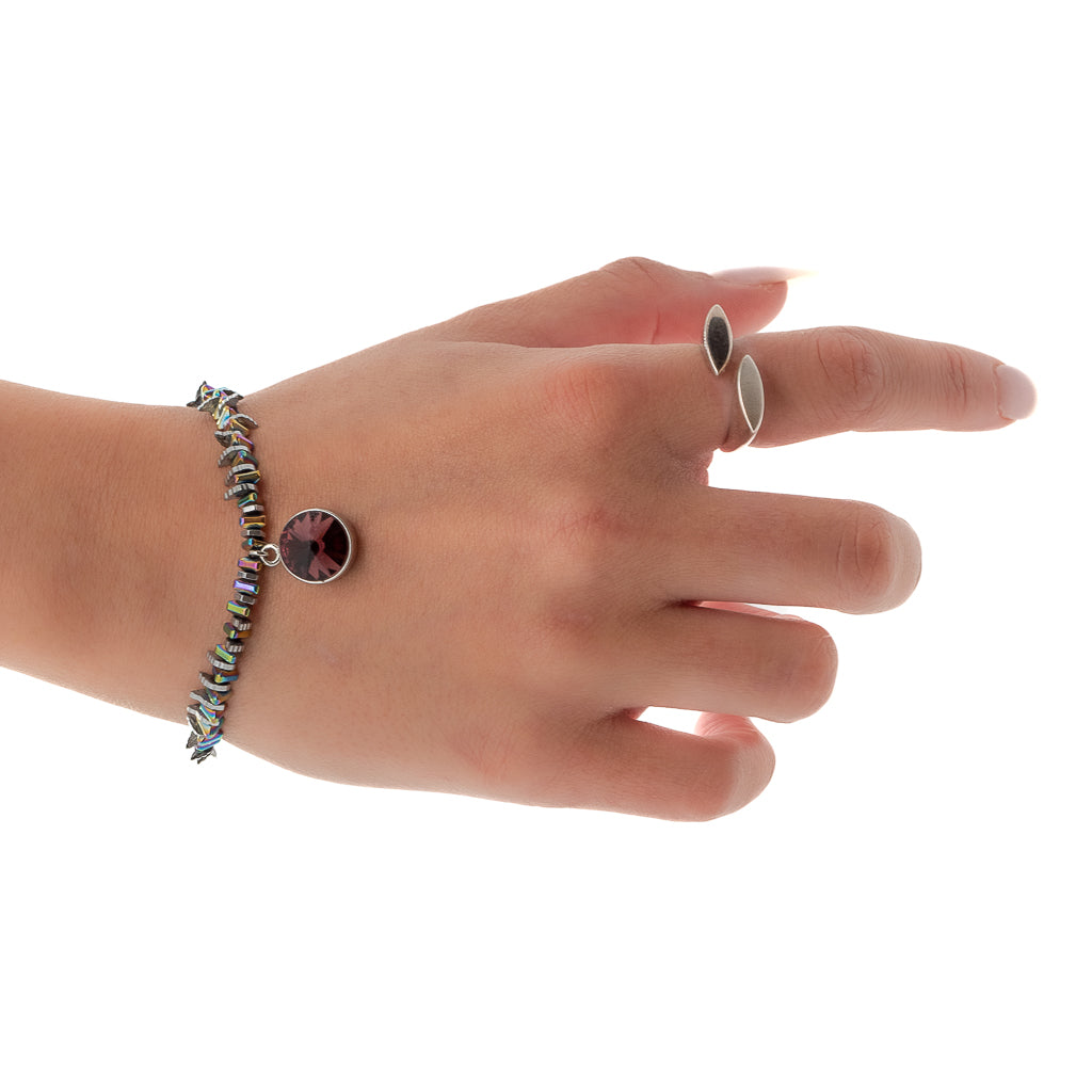 Hand model showcases the elegance and charm of the Purple Magic Bracelet, adorned with multicolor hematite beads and a captivating Swarovski charm.