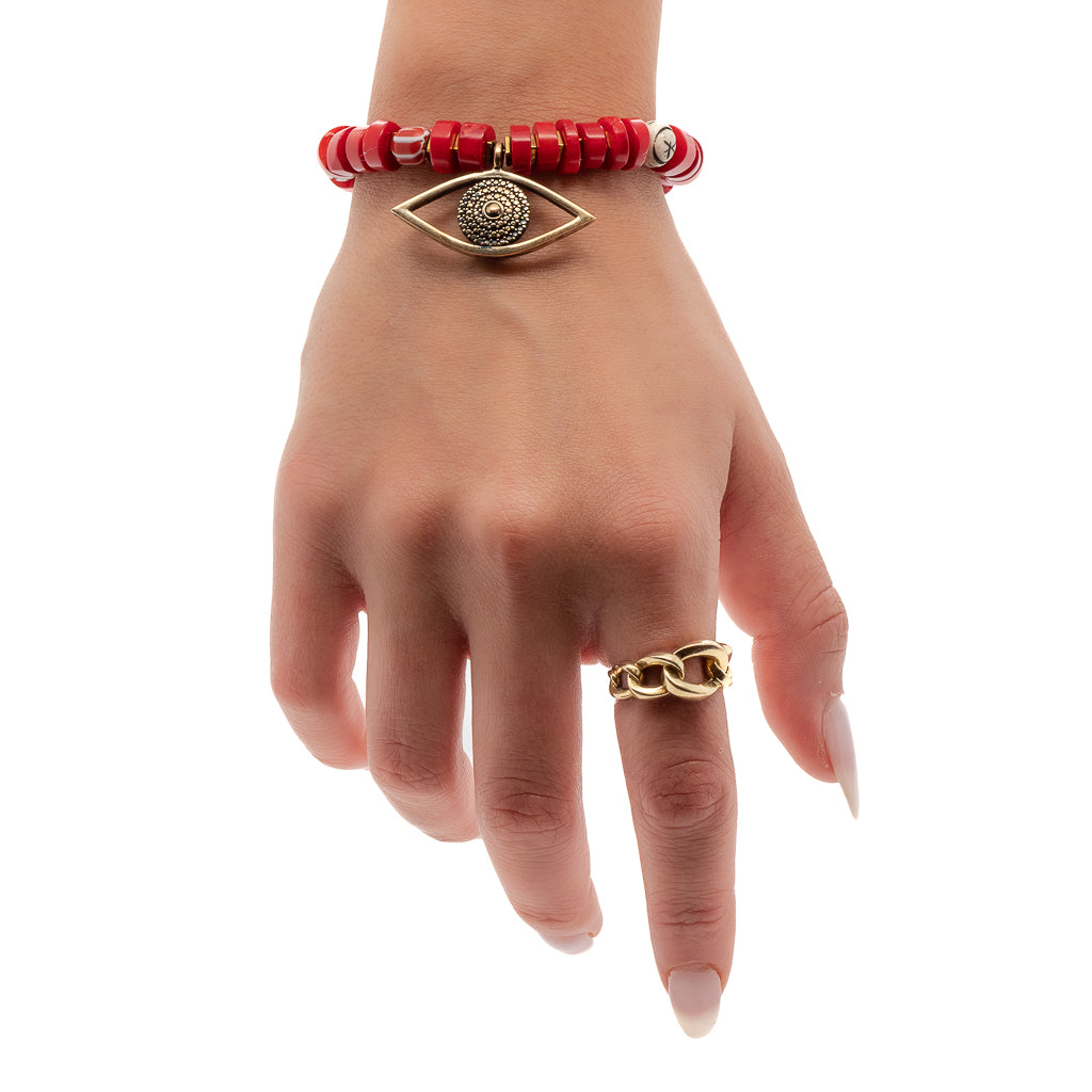 See how the Red Coral Evil Eye Bracelet adds a vibrant touch to the hand model&#39;s style, with its powerful combination of red coral beads and an enchanting evil eye charm.