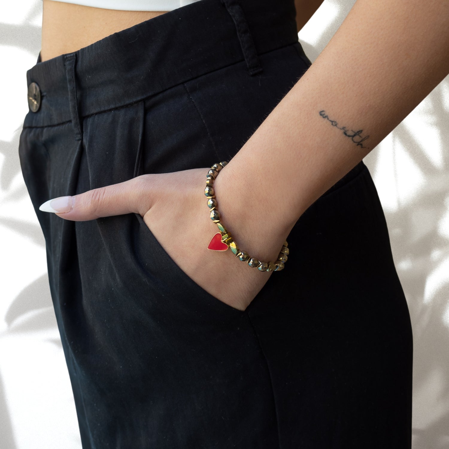 The hand model showcases the Red Heart Love Bracelet, a symbol of love and elegance, adding a touch of charm to her ensemble.
