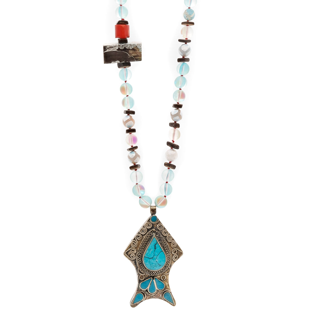 The fish pendant is expertly crafted with intricate details and embellished with a beautiful turquoise stone that complements the aqua and blue tones of the necklace.