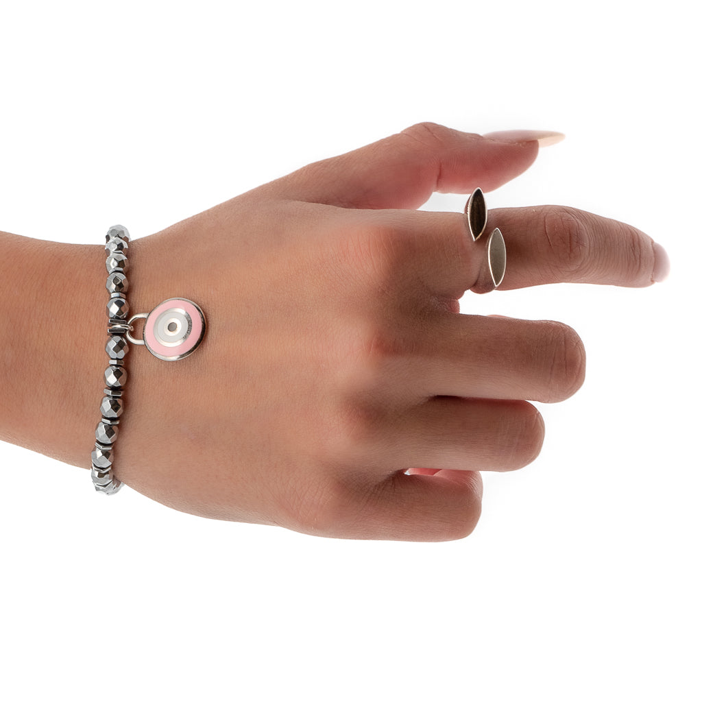 The hand model showcases the elegance and spirituality of the Spiritual Pink Evil Eye Bracelet, featuring silver hematite stone beads and a Sterling silver pink enamel evil eye charm.