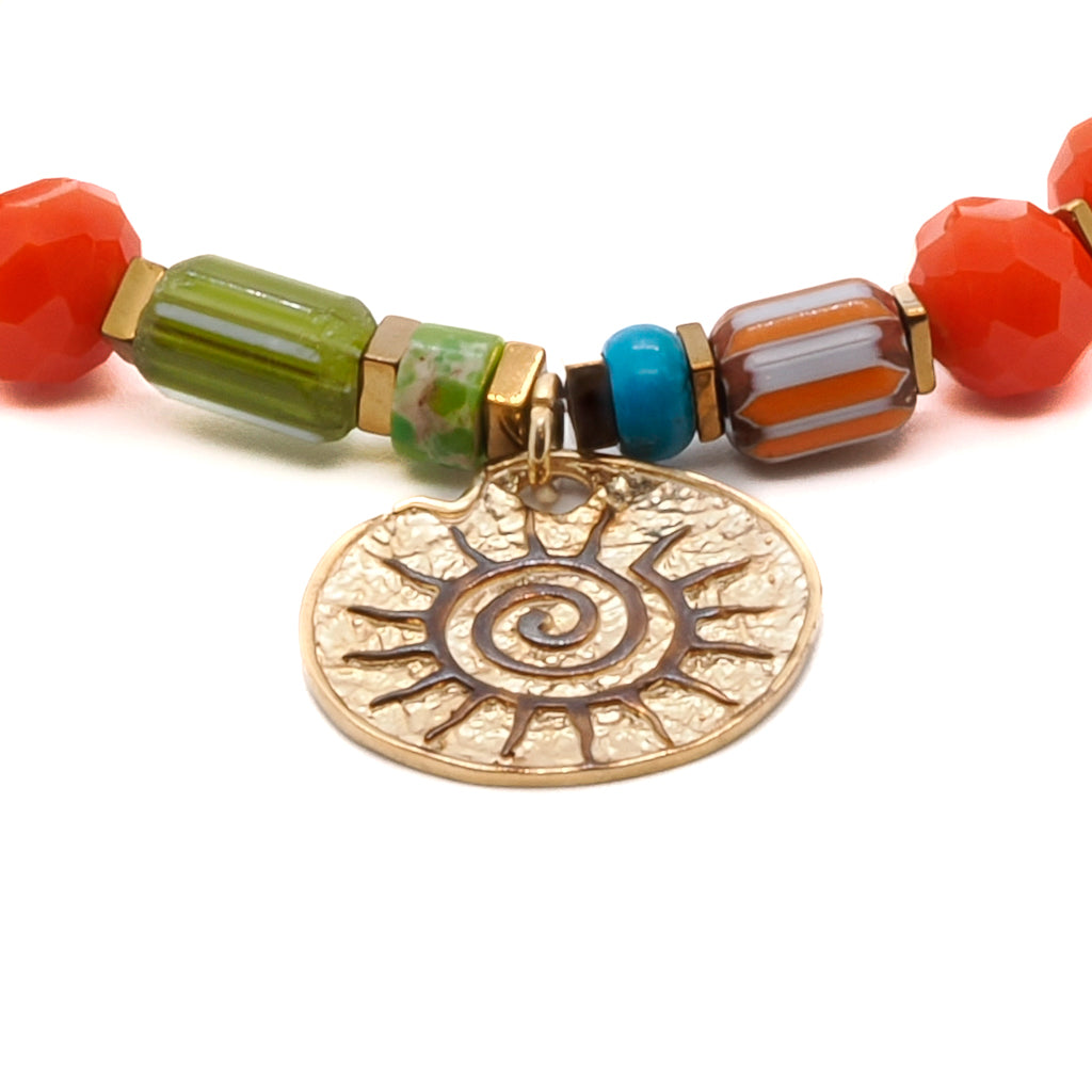 Elevate your style with the Spiritual Sun Bracelet, featuring bright orange crystal beads, gold hematite spacers, and a sterling silver sun charm.