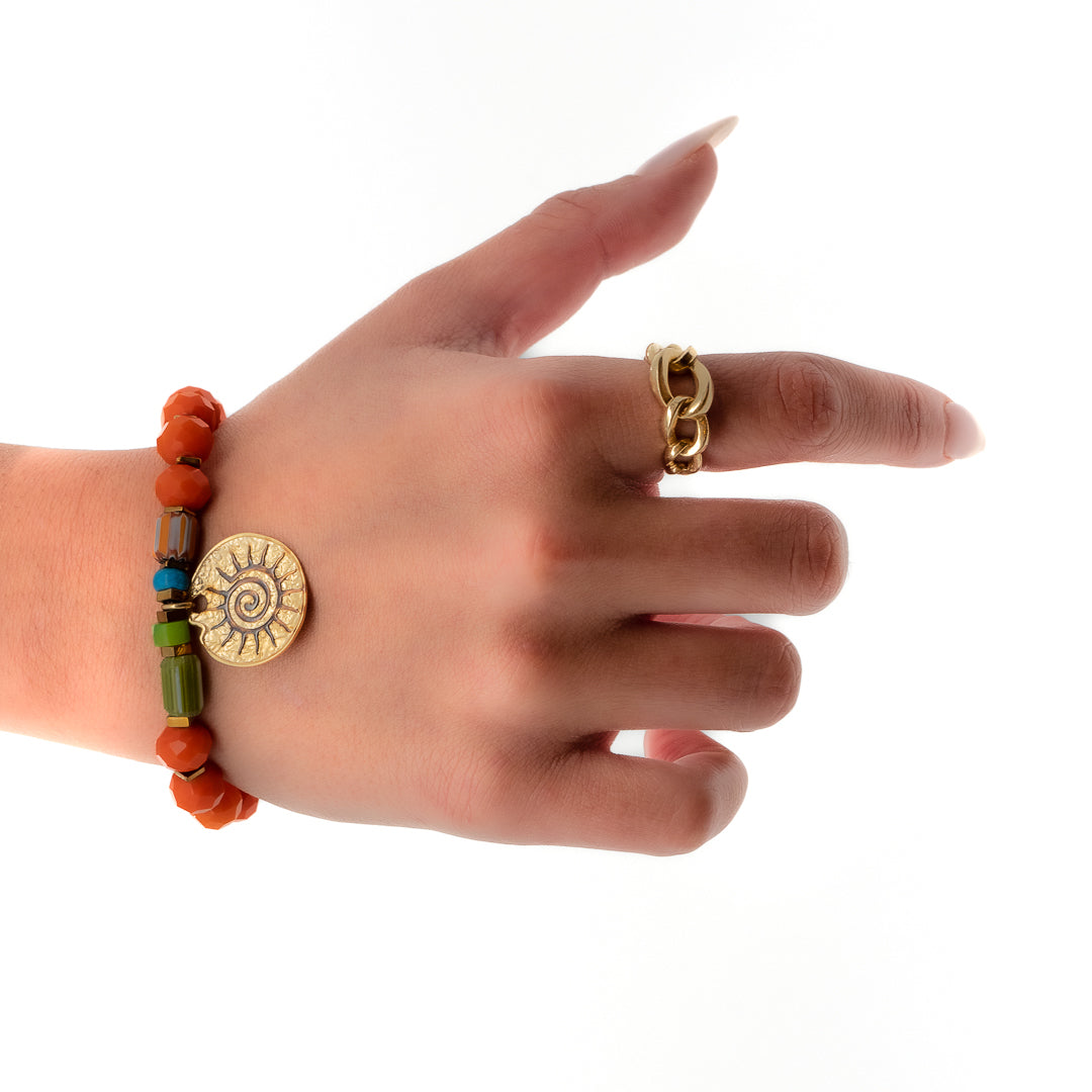 The hand model showcases the vibrant energy of the Spiritual Sun Bracelet, adorned with orange crystal beads, gold hematite spacers, and a sterling silver sun charm.