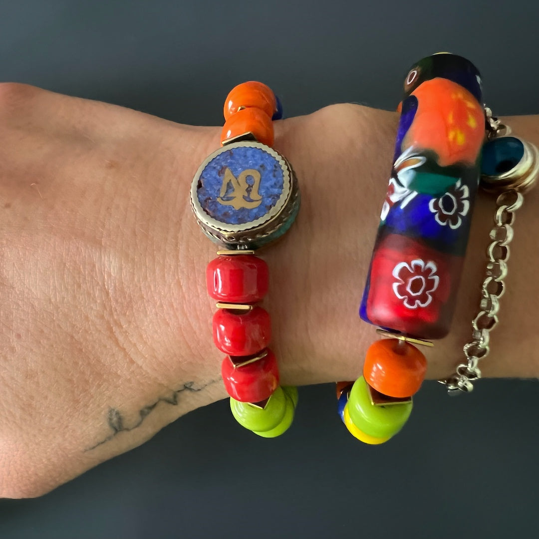 The hand model effortlessly showcases the Spring Vibes Bracelet, a handmade piece that captures the essence of the season with its colorful Indian beads, gold hematite spacers, and vibrant African bead.