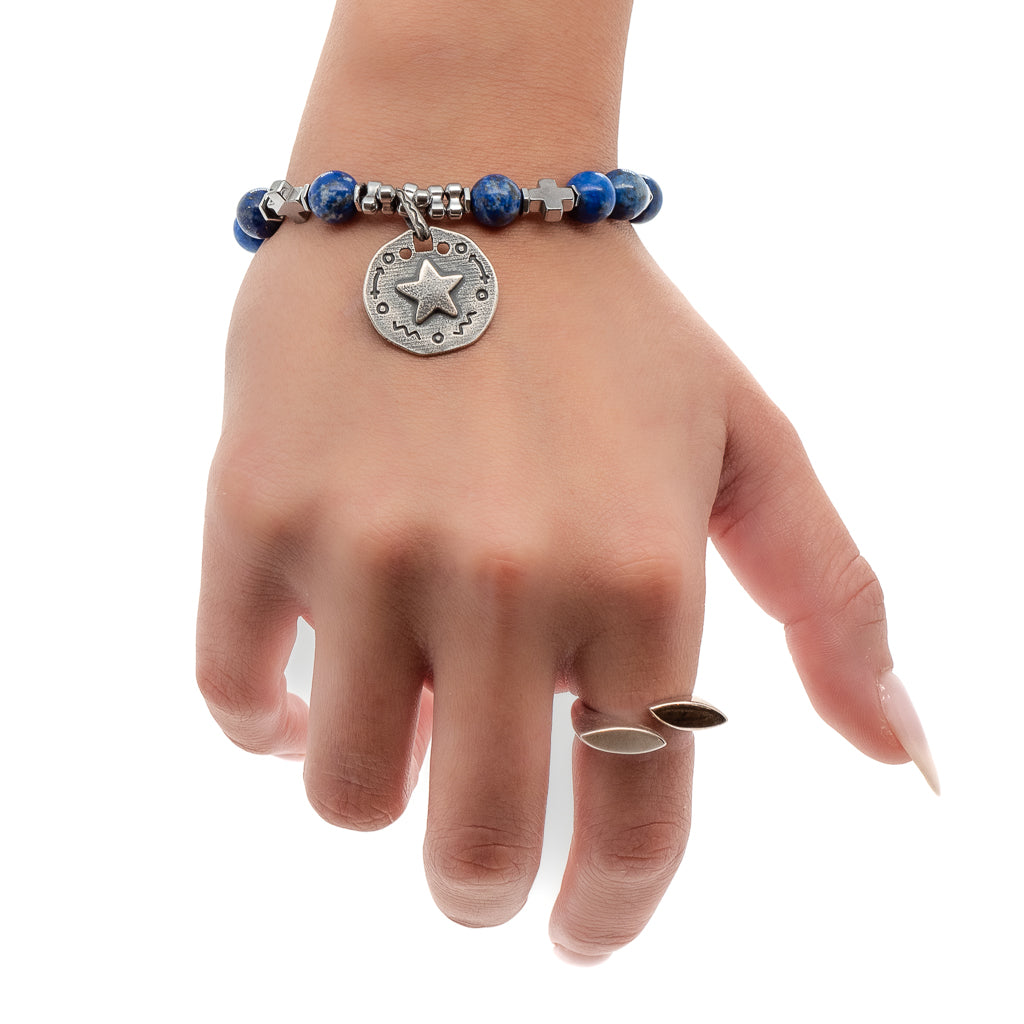 See how the Star Blue Lapis Lazuli Bracelet enhances the hand model&#39;s style with its vibrant blue beads and celestial-inspired charm.