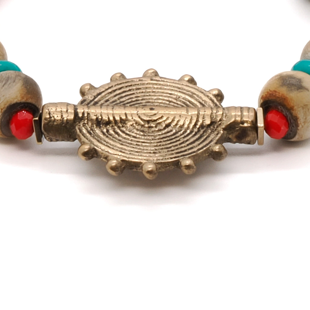 Admire the intricate craftsmanship of the Tibetan Ethnic Bracelet, showcasing its textured Nepal seed beads and vibrant turquoise stone.